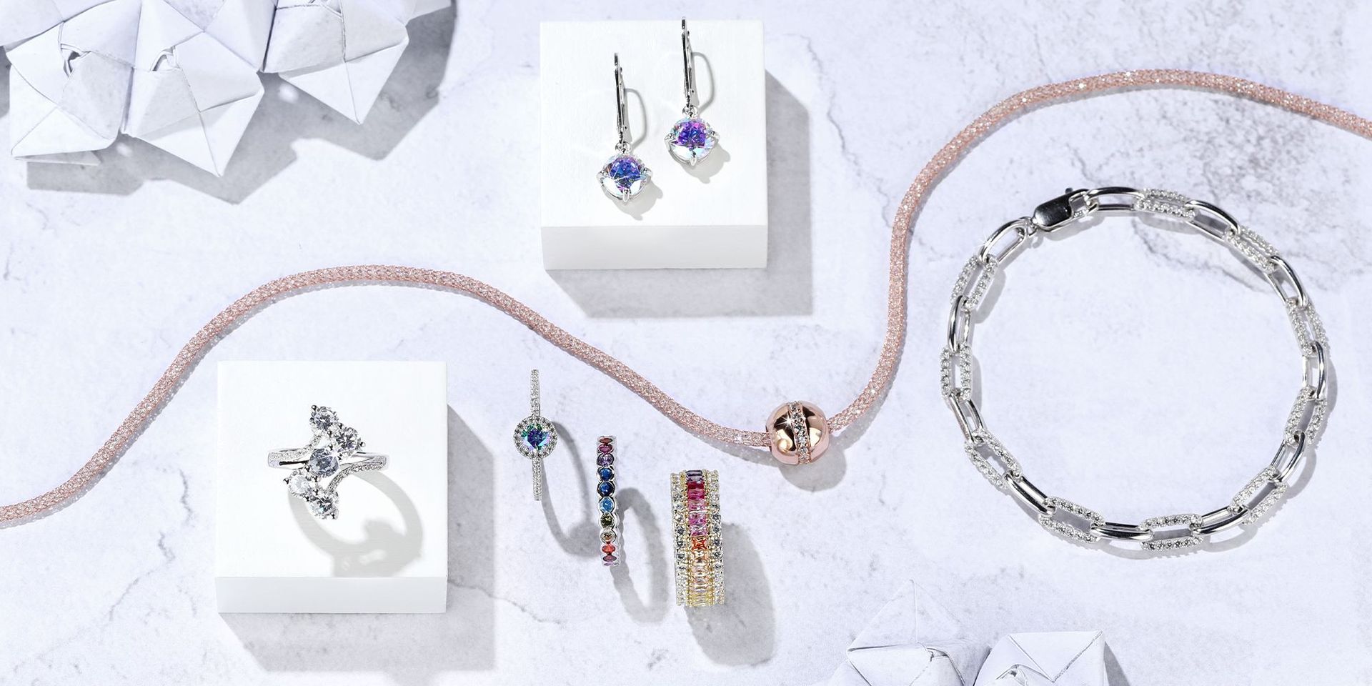 Schmuckset mit funkelnden Ringen und Ohrringen auf hellem Hintergrund
