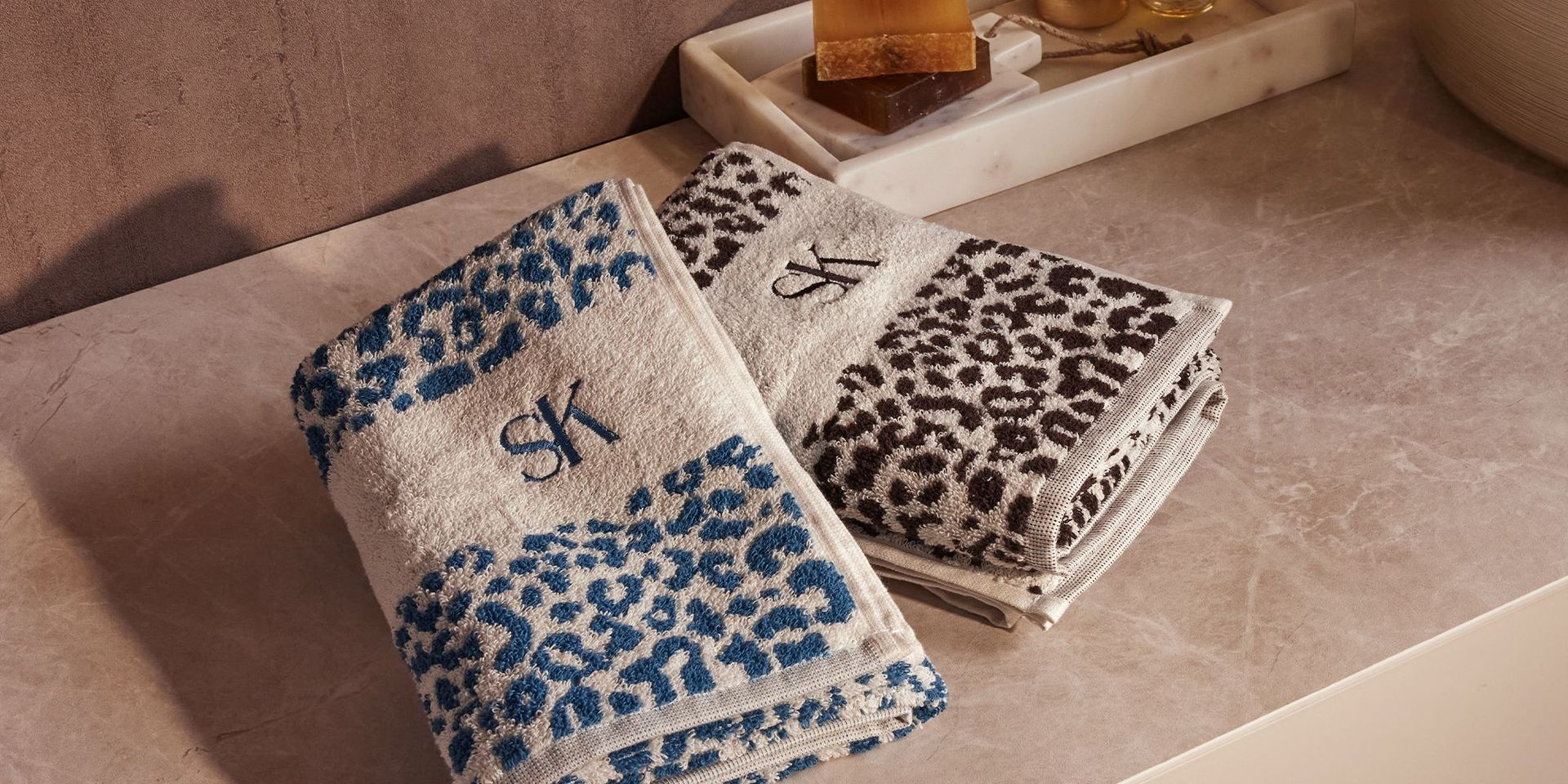 Sarah Kern Badtextilien mit blauem und schwarzem Leopardenmuster auf Marmorablage