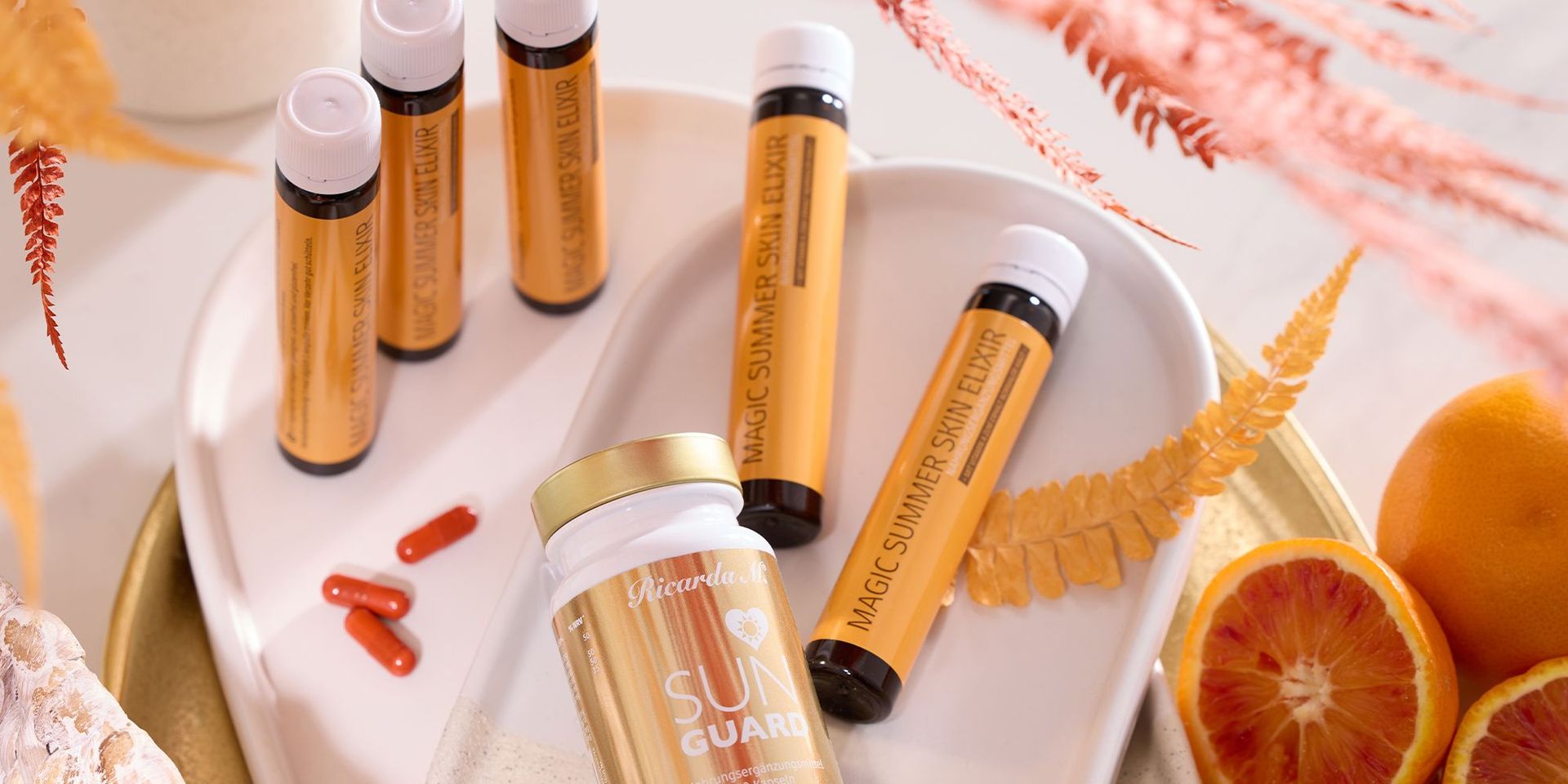Nahrungsergänzungsmittel Ricarda M mit Orangen und Tabletten auf Tablett