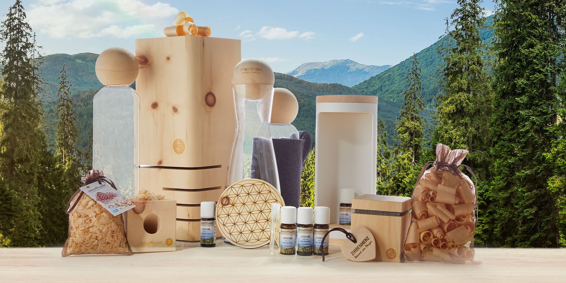 Produkte aus der Zirbenfamilie vor einer bergigen Landschaft und grünen Tannen.
