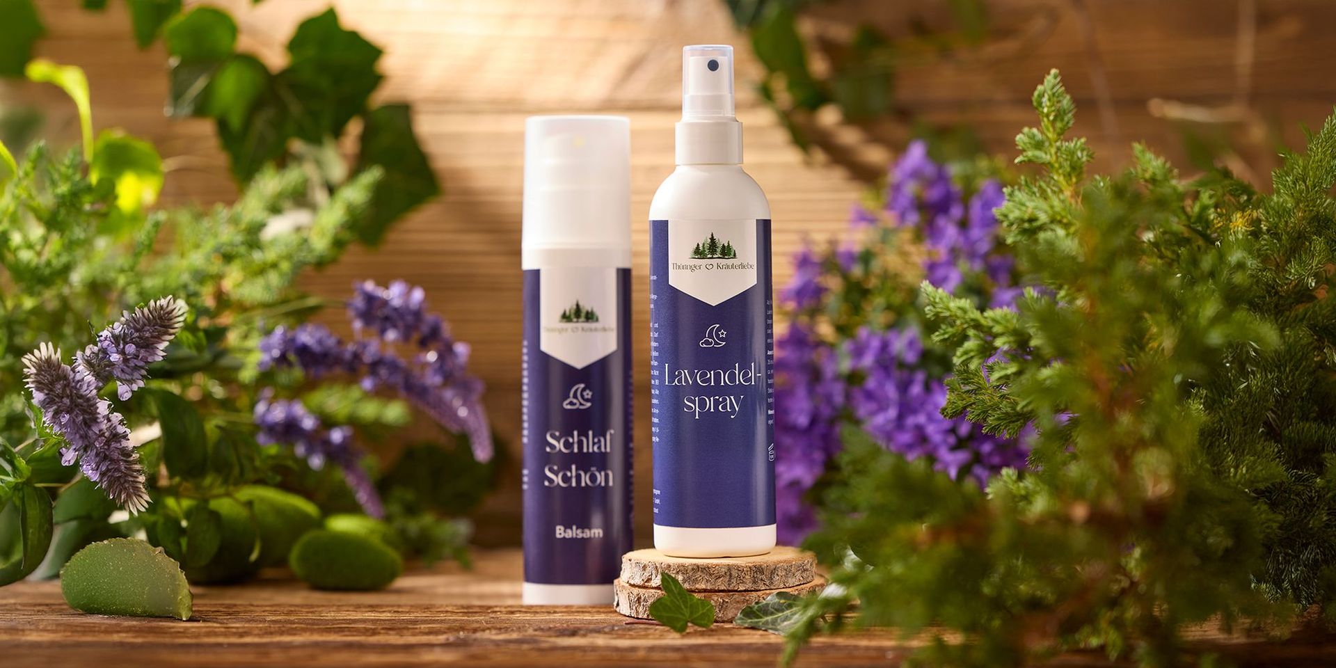Thüringer Kräuterhof Lavendelspray und Schlaf Schön Balsam auf Holzuntergrund, umgeben von Lavendelblüten