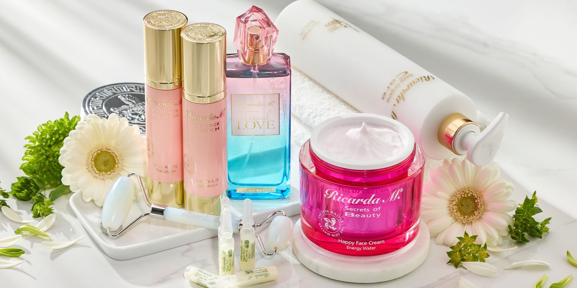 Ricarda M. Beauty-Produkte auf einem weißen Hintergrund umgeben von weißen Blumen