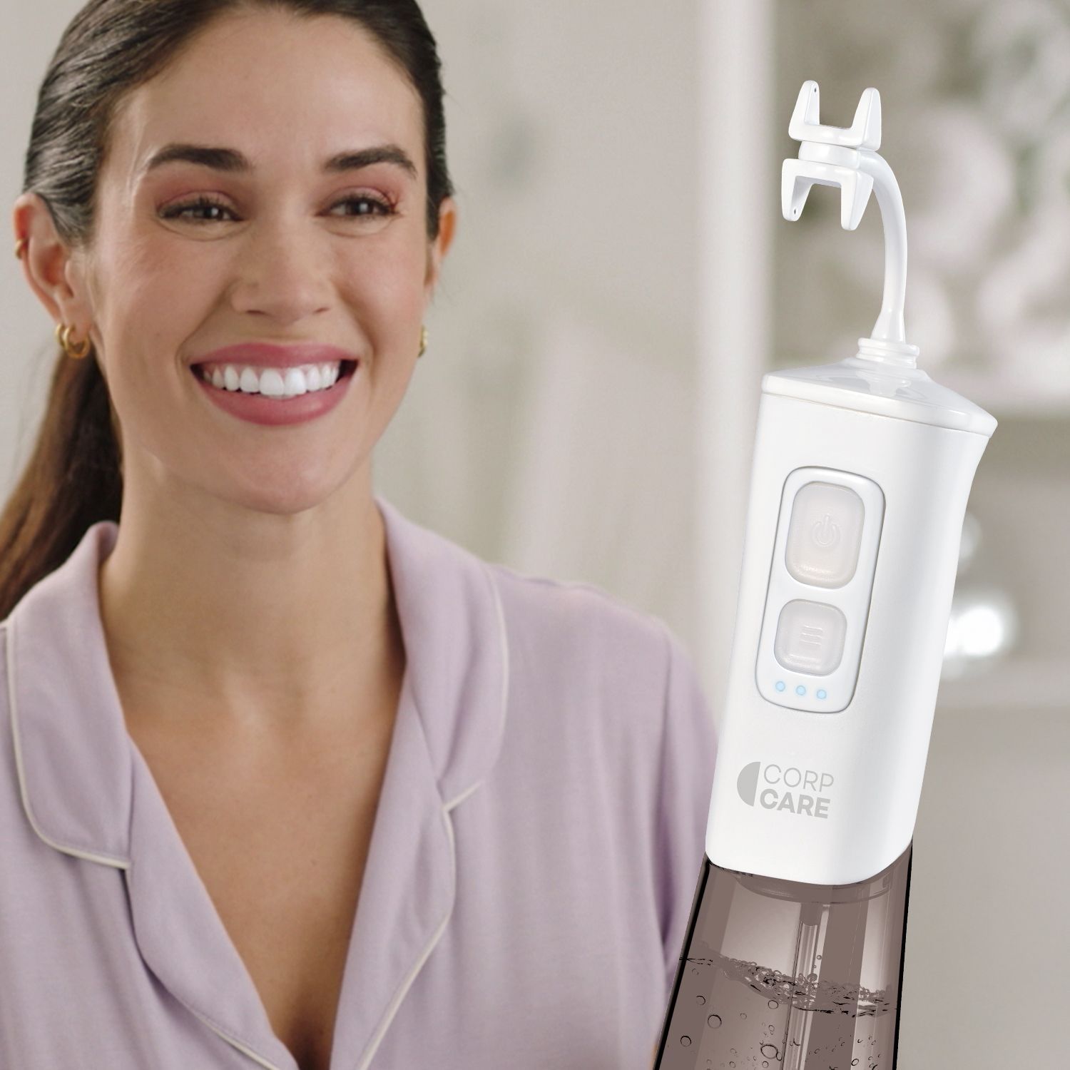 Im Vordergrund die Munddusche "Miracle Smile", im Hintergrund ein Mann, der die Munddusche anwendet