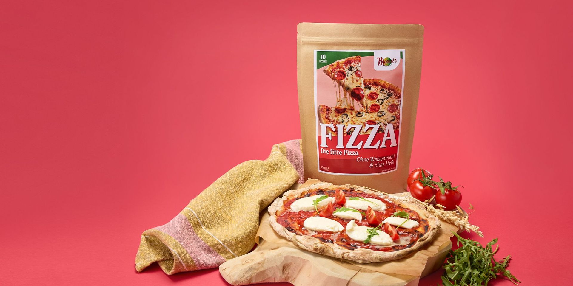 Pizzateig-Mischung in brauner Verpackung mit frischen Tomaten und Rucola