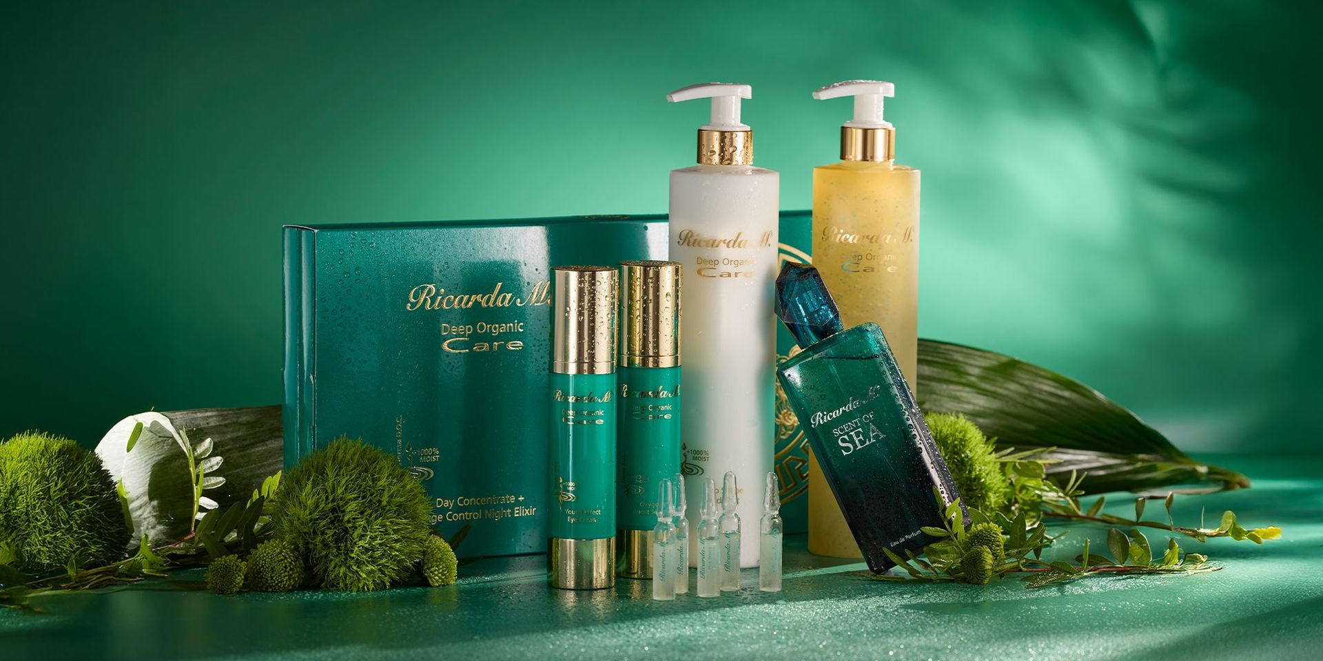 Ricarda M. Deep Organic Care Hautpflegeprodukte, darunter Tageskonzentrat, Nachtelixier, zwei Pumpflaschen und Ampullen, arrangiert mit grünen Pflanzen