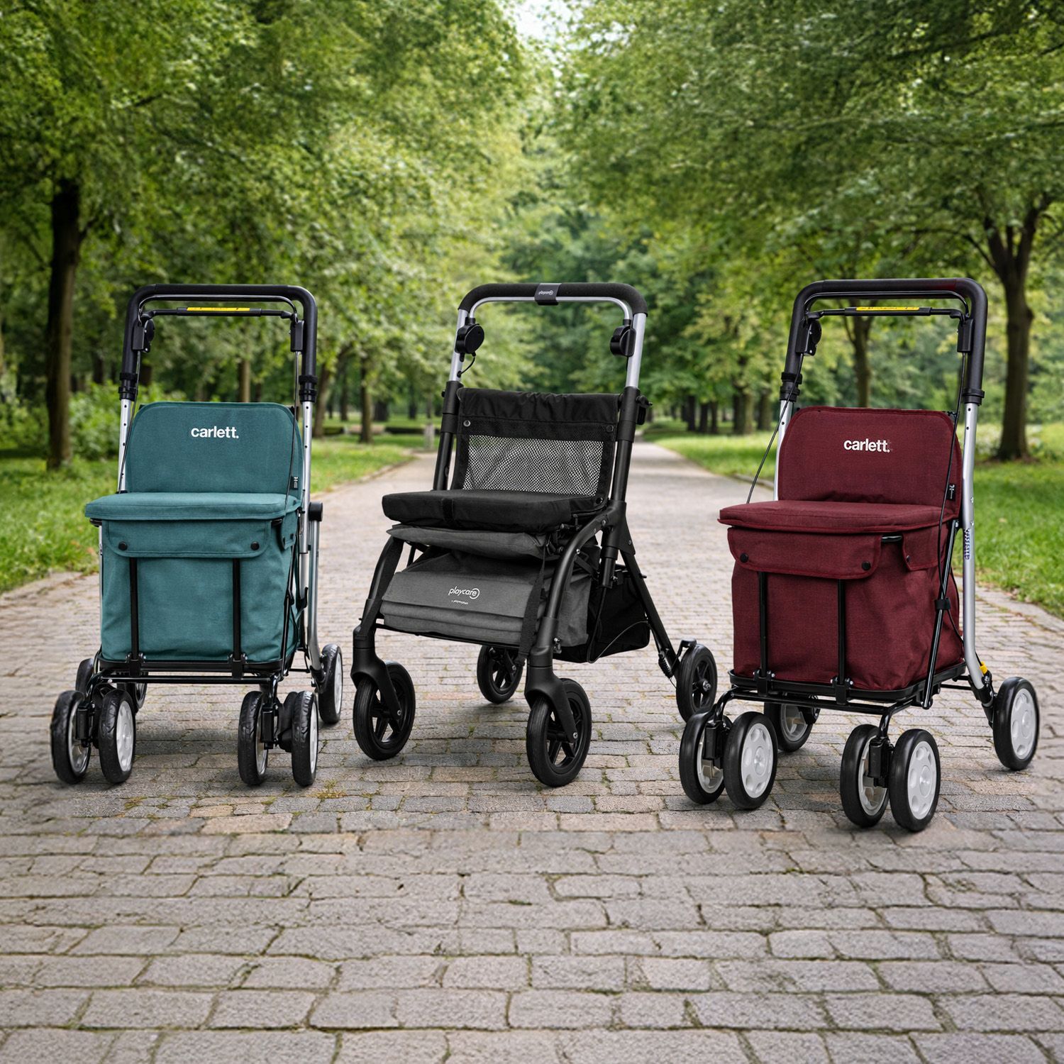 Drei Einkaufstrolley mit vier Rädern und Stofftaschen in Grün, Schwarz und Dunkelrot auf gepflastertem Weg im Park
