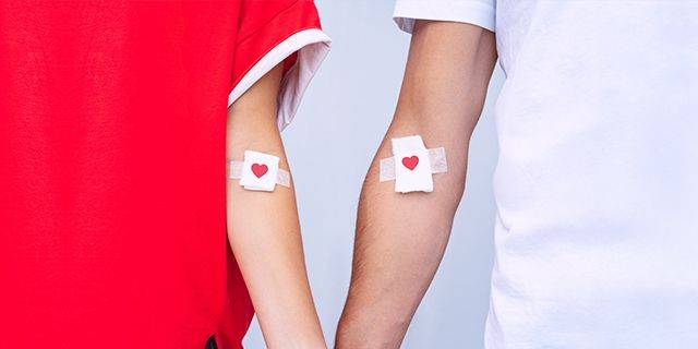 Blutspende Zwei Arme mit Pflastern, die ein rotes Herz zeigen, symbolisieren eine Blutspende