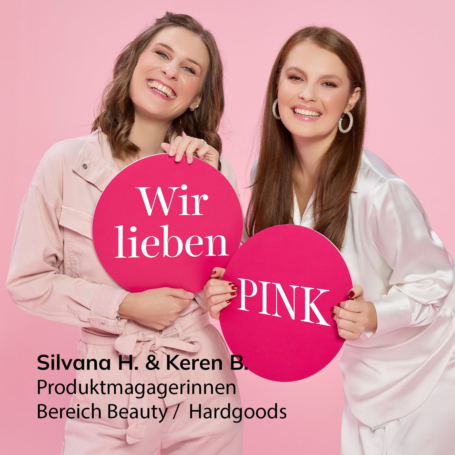 Unsere pinken Angebote Zwei Frauen in hellrosa und weißer Kleidung halten pinkfarbene runde Schilder mit den Worten 'Wir lieben' und 'PINK' vor einem rosa Hintergrund.