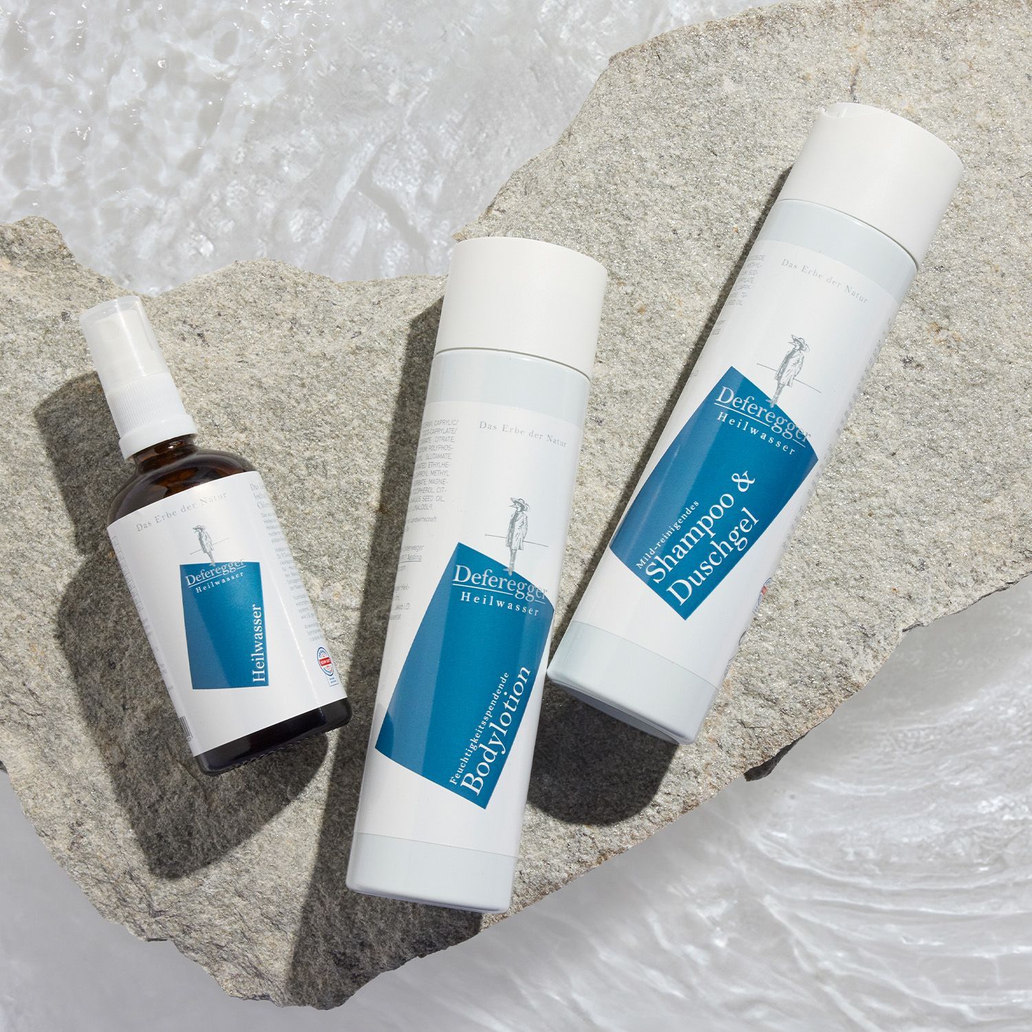 Deferegger Heilwasser – Angebote entdecken Drei Deferegger Heilwasser-Produkte auf hellem Stein liegend darunter eine Sprühflasche, eine Flasche Bodylotion und eine Flasche Shampoo & Duschgel