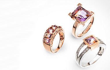 Drei Ringe mit lila Edelsteinen von Gemondo. Zwei davon sind gold, einer ist silber.